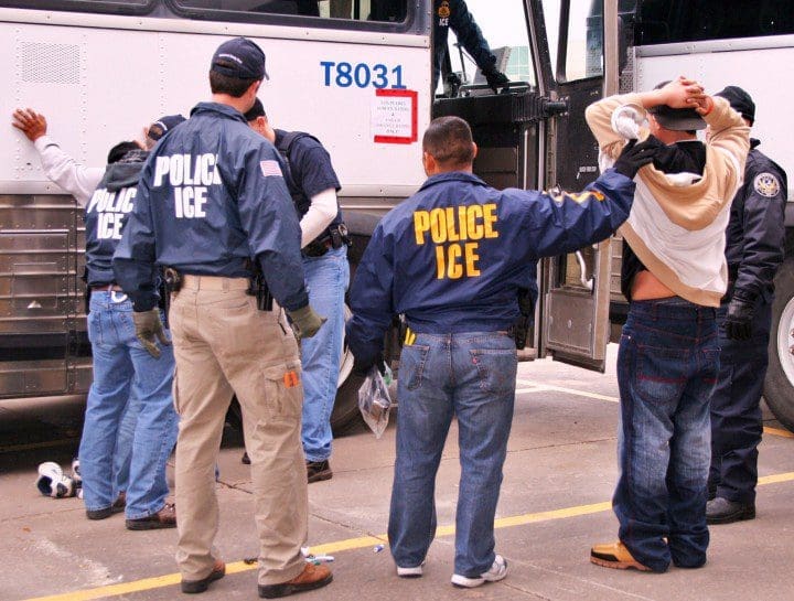 United States Immigration police detaining migrants as they get off of the bus