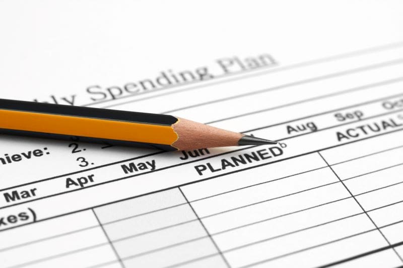 A monthly spending plan chart with a pencil on top of the page
