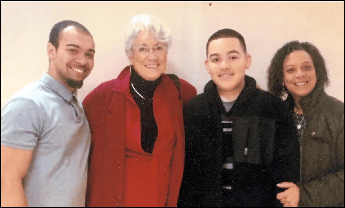 Four people posing for a photograph together with smiles.