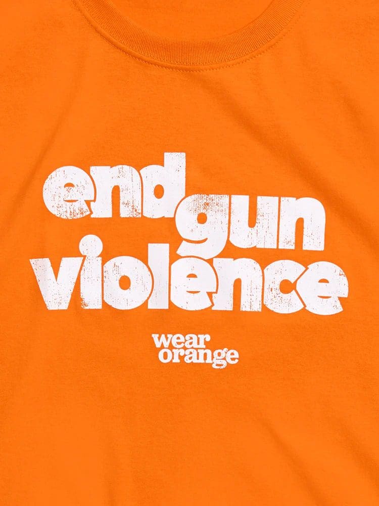 An orange shirt with the text "end gun violence" in white, bold, distressed font, and "wear orange" beneath it in smaller letters.